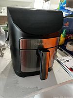 Front view of Gourmia air fryer with black and stainless steel finish, showing brand name and basket handle.