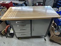 Front view of workstation showing four drawers, cabinet and wooden top
