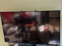 Front view of the black-framed Vizio 55-inch LED TV screen, turned off, showing reflection but no visible damage or imperfections on screen surface.