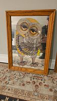 Framed mirror with etched owl artwork standing on a patterned rug, showing full view.