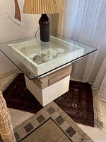 Full view of the white plaster base side table with square glass top showing the overall design and placement in room.