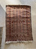 Full front view of rug laying flat showing overall design, color and fringe.