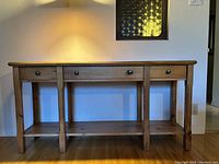Front view of sideboard showing three drawers and lower shelf