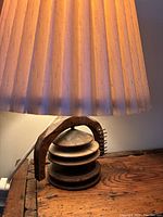 Close-up of small antique table lamp base and shade showing design details and material.