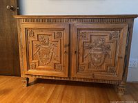 Front view of two-door wooden cabinet with carved panels