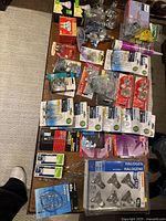 Overall assortment of light bulbs and hardware arranged on a table with packaging from multiple brands visible.