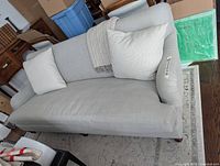 Front angled view of the sofa with two throw pillows