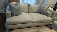 Front view of the full sofa with cushions and pillows on rug