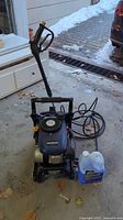 Pressure washer front view with hose coiled and detergent jug at side