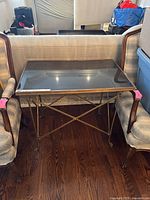 Front view showing stone top and brass frame between two chairs