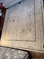 Full view of the rug under a sofa and coffee table, showing overall pattern and condition.