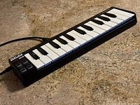 Front angled view of Akai LPK25 MIDI keyboard controller showing 25 keys and control buttons.