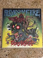 Front cover artwork of Alexisonfire Dogs Blood vinyl featuring a monstrous horse head and vivid colors.
