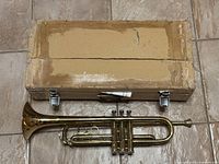 Open wooden case with trumpet inside, showing case interior and instrument placement