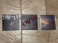 Front covers of three 45 vinyl records: two by C/Hunter with stencil lettering, one with mountain landscape photo