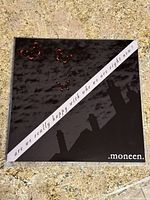 Front cover of the vinyl record featuring a black textured background with a silhouette of rooftops and red butterflies. Diagonal text reads the album title.