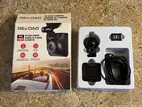 Reload HD Dash Camera in packaging showing camera, suction mount, microSD card, and power cable.