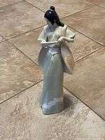 Front view of Royal Doulton Reflections Cherry Blossom porcelain figurine, showing pale green kimono with gradient and folded fan in hands.