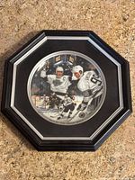 Full view of framed circular plate commemorating Wayne Gretzky's 802nd point, set in octagonal black frame on carpet.