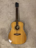 Full front view of guitar showing body, neck, and headstock on carpet