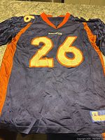Front of the navy blue mesh football jersey with orange number 26 and Broncos text on front.