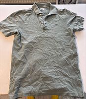 Full view of vintage Lacoste men's polo shirt laid out flat, showing size 5 fit and button-up collar.