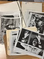 Lot of scattered black-and-white press photos and typed notes related to the films International Velvet, Sweet Revenge, and Audrey Rose shown piled on a wooden surface.