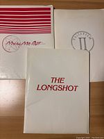 Three press kit folders titled Making Mr. Right, Italia Film II, and THE LONGSHOT shown from front, laying on wooden surface.