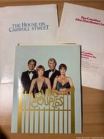 Flat-lay photo of three folders and brochures, showing titles 'The House on Carroll Street', glossy cover with four actors for 'Loving Couples', and Pan-Canadian Film Distributors Inc. folder