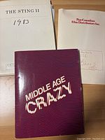 Printed materials including The Sting II press kit dated 1983, Pan-Canadian Film Distributors Inc. folder, and Middle Age Crazy booklet with distinctive red and purple cover.