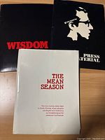 Three press kits or promotional materials for three films: Wisdom, The Front, and The Mean Season, each with distinctive cover designs.