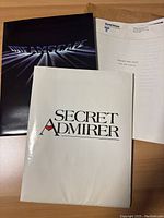 Dreamscape folder with movie logo, Secret Admirer booklet, and Message from Space notes on United Artists letterhead laid out on wooden surface