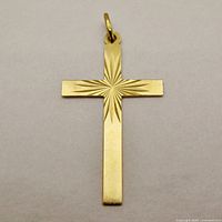 Front view of gold cross pendant showing sunburst engraving