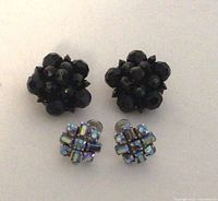 Full view of both pairs of vintage Sherman earrings on white background, showing black layered bead clip-on earrings and smaller aurora borealis crystal screw-back earrings.