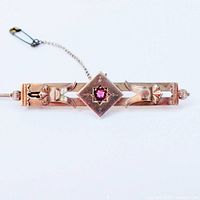 Front view of bar brooch showing geometric design and central faux ruby