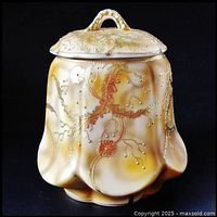 Front and side view of antique Nippon lidded jar showing mottled cream, orange, and brown background with raised gold gilt floral swirls and gold beading.