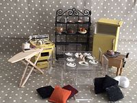 Full set including yellow wooden stove and fridge, acrylic chairs and table, black metal rack with dishes and food items, ironing board with miniatures