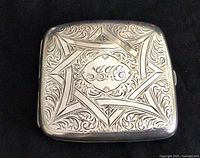 Front of the Edwardian sterling silver cigarette case showing elaborate engraving and monogram.