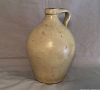 Front view of the stoneware crock showing its full ovoid shape and handle.