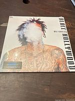 Front cover of brand new sealed Wiz Khalifa Blacc Hollywood LP album showing smoke obscuring the artist's face and detailed tattoos.