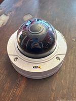 Front view of the fake dome security camera showing the Axis logo and glossy black dome with fake lens inside.
