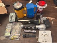 Top view of assorted flashlights, battery charger, battery packets, and power strip.