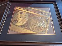 Framed Joan Blaeu double hemisphere world map showing full view with visible frame and glass reflection.