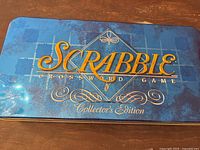 Metal storage tin lid with Scrabble Collector's Edition logo in gold on blue background.