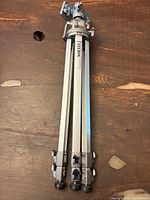 Folded Velbon VS3 tripod showing aluminum legs with clasp locks and tripod head at top.