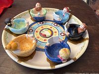 Full view of the Seder plate with six removable figurine bowls seated around the plate's divisions.