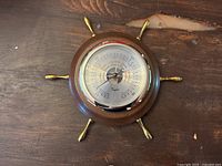 Full view of the vintage Taylor barometer with nautical ship wheel design, showing wooden frame and brass handles.