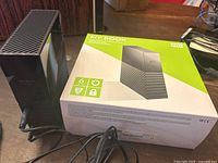 Front view of Western Digital My Book 6TB external hard drive next to its original product box showing the device's design and branding.