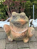 Front view of the clay frog planter showing floral pattern and weathered surface