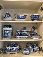 Three-shelf cabinet view showing entire collection of blue and white china pieces.